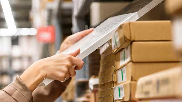 Woman picking a box from a shelf