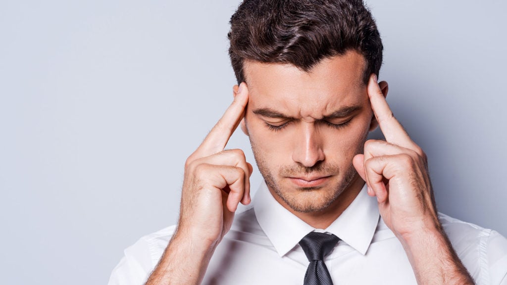 A man squeezing his temples with his fingers