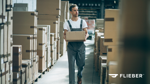 A man carrying a box on a wharehouse